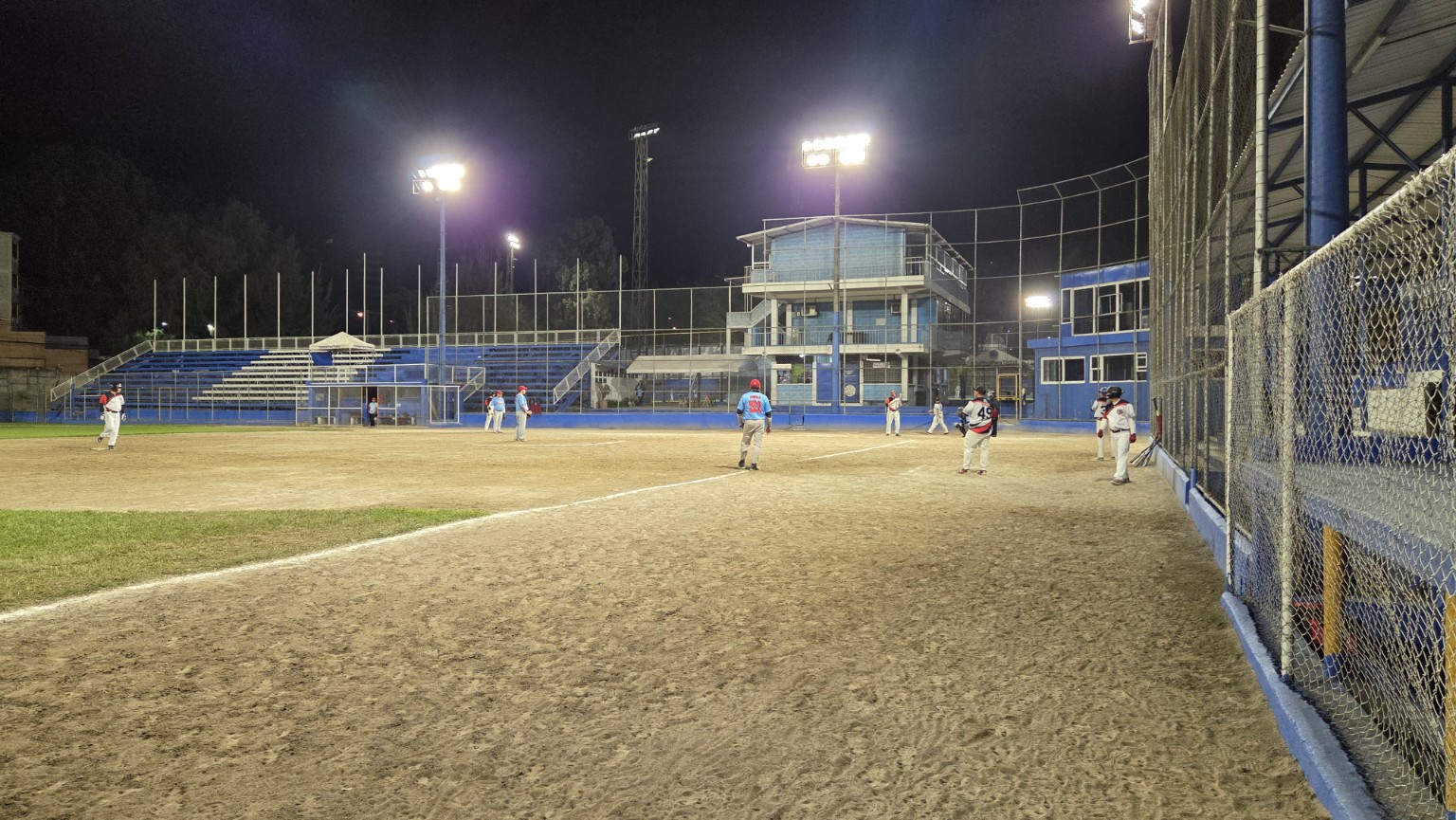 Jugadores reunidos durante un partido nocturno de softbol